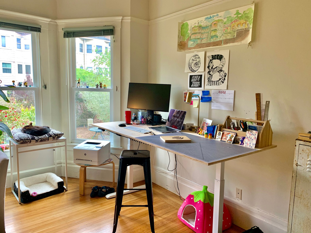 Desiigner's workstation with figures on the windows and a dog on the left side of the room